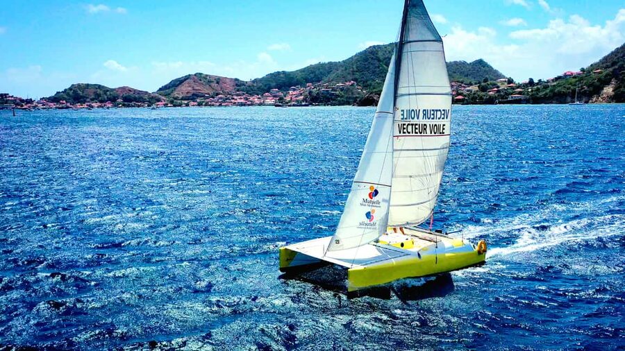 Sailing catamaran in La Baie des Saintes - Finding Saga beside the Terre de Haut ferry dock